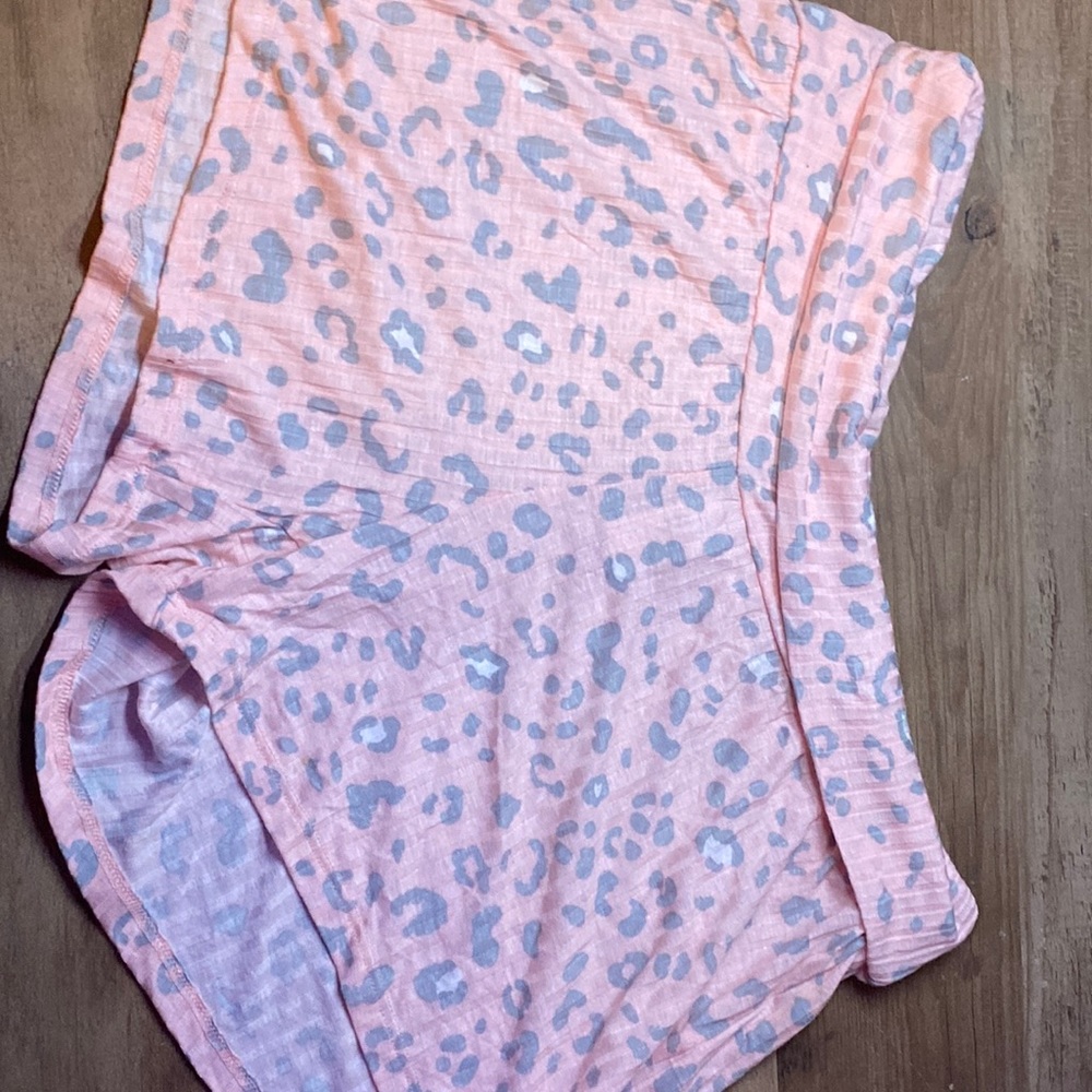 These are some pink, grey, and white cheetah print sleep shorts.